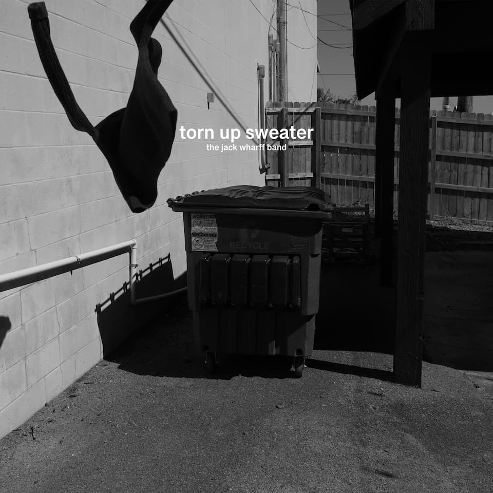 Torn Up Sweater cover art: a torn sweater caught on a wire above a dumpster in a sunlit alley